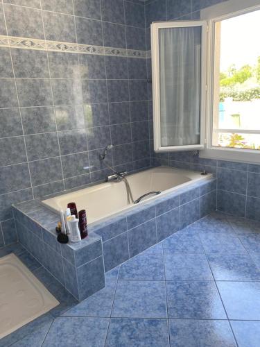une baignoire dans une salle de bain avec une fenêtre dans l'établissement Coastal bliss, à Grand-Village-Plage