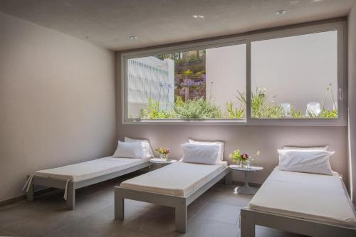 twee bedden in een kamer met twee ramen bij Vizion Suites by CELTIS in Carilo