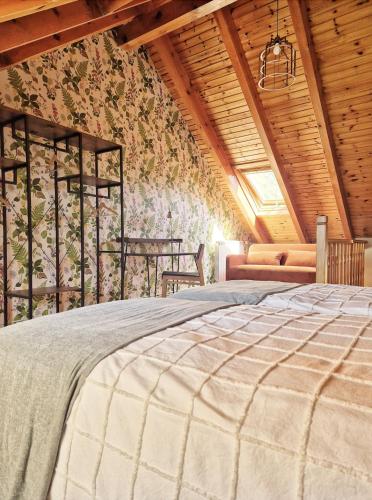 a bedroom with a bed and a wooden ceiling at El Puyal de Benas in Benasque