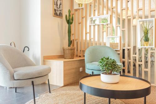 two chairs and a coffee table in a living room at Kyriad Anglet - Biarritz in Anglet