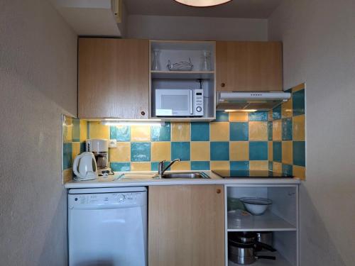une petite cuisine avec un évier et un micro-ondes dans l'établissement Saint François Longchamp - 8 pers, 65 m², 4/3 - FR-1-807-126, à Saint-François-Longchamp