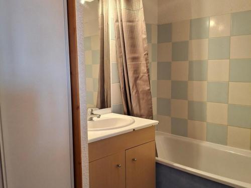 une salle de bain avec un lavabo et une baignoire dans l'établissement Saint François Longchamp - 8 pers, 65 m², 4/3 - FR-1-807-126, à Saint-François-Longchamp