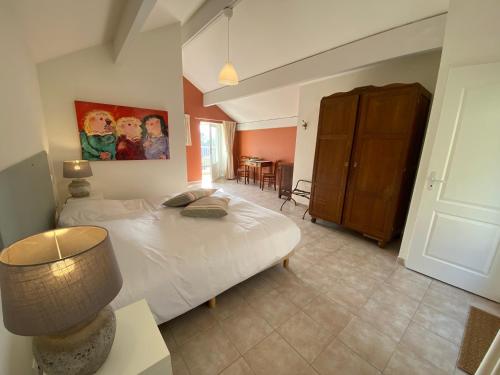 a bedroom with a bed with a lamp and a table at Combe Rouge in Belvèze