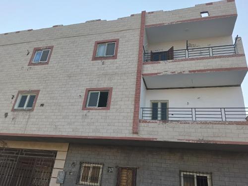 a building with a balcony on the side of it at Guest house science W 1 in Marsa Alam City