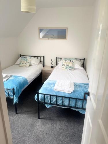 two twin beds in a room withthritisthritisthritisthritisthritisthritisthritisthritisthritis at Dream Weaver 2 Bedroomed cottage on The Bay, Filey with on-site gym and swimming pool in Filey