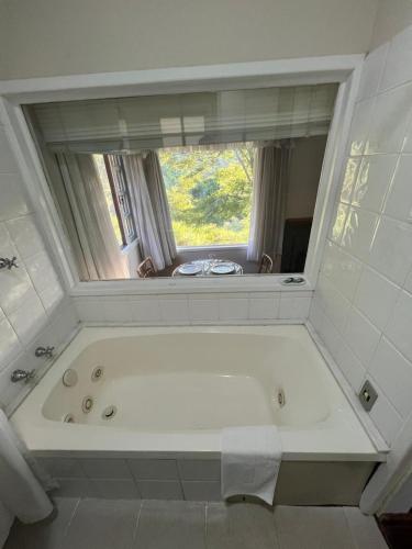 a bath tub in a bathroom with a window at Chalés da montanha in Itaipava