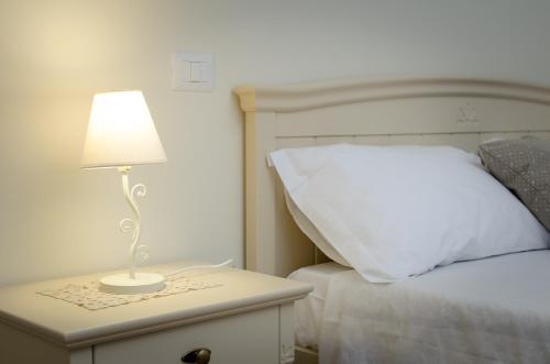 a lamp on a night stand next to a bed at Agriturismo Tenuta Umberto I in Ripacorbaria