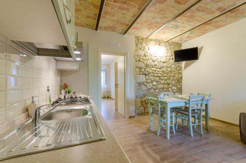 a kitchen with a sink and a table with chairs at Agriturismo Tenuta Umberto I in Ripacorbaria