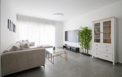 una sala de estar con un sofá y una mesa en The most special 3-BDR on Achziv, en Nahariyya