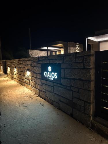 a sign on a brick wall at night at Gialos Villas Paleochora in Palaiochóra