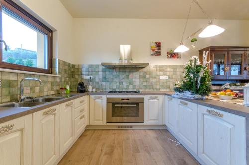 a kitchen with white cabinets and a sink at Agriturismo Tenuta Umberto I in Ripacorbaria