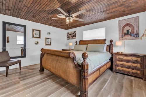 una camera con letto in legno e ventilatore a soffitto di Family Luxury Rentals - 1115 a Lantana