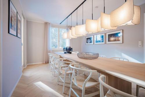a long dining room with a long bar with stools at Ferienhaus Beatus ille in Kolpinsee