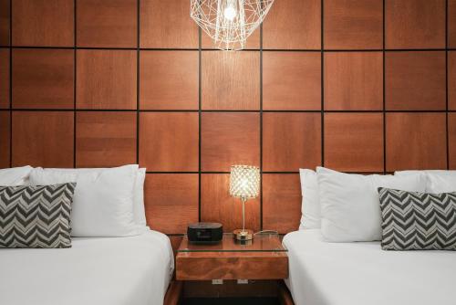 a hotel room with two beds and a table with a lamp at Chesterfield Hotel & Suites in Miami Beach