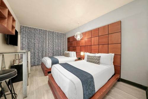 a hotel room with two beds and a window at Chesterfield Hotel & Suites in Miami Beach