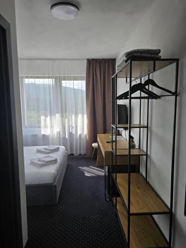 ein Hotelzimmer mit einem Bett und einem Bücherregal in der Unterkunft Nort Inn - Luncile Prigoanei, Sureanu, Oasa, Transalpina in Tău Bistra
