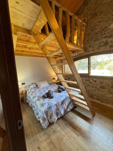 a bedroom with a bed and a wooden ceiling at Ca l'Esclatat in Santa María de Palautordera