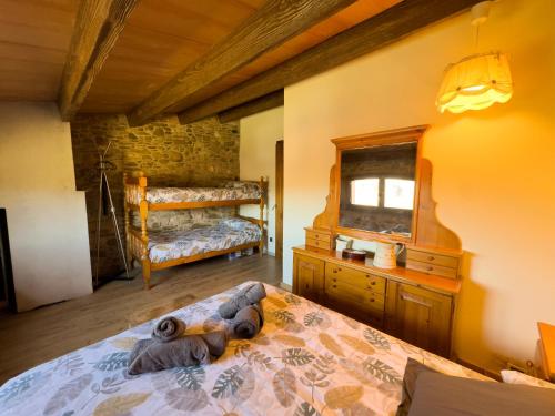 a bedroom with a bed with a dresser and a mirror at Ca l'Esclatat in Santa María de Palautordera