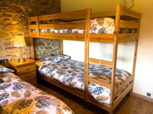 a bedroom with two bunk beds and a lamp at Ca l'Esclatat in Santa María de Palautordera
