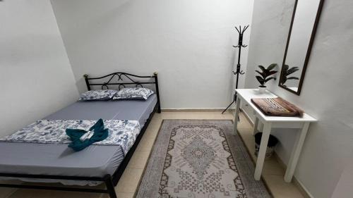 Un dormitorio con una cama, una mesa y un escritorio. en D'Simpang Homestay, en Sungai Petani