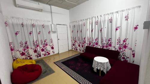 sala de estar con sofá rojo y flores en la pared en D'Simpang Homestay, en Sungai Petani