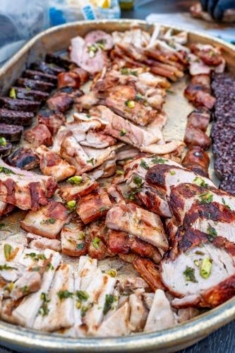a pan filled with chicken and other meats on a table at Villa Dinastía Resort Lujo in Llucmajor