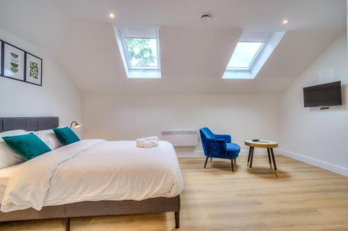 a bedroom with a bed and a blue chair at Luxury Penthouse Flat Manchester in Wythenshawe