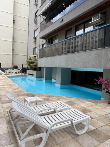 a pair of lounge chairs sitting in front of a building at Apartamento em Copacabana in Rio de Janeiro