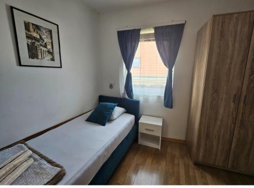 a small bedroom with a bed and a window at Pansion Most , Mostar in Mostar