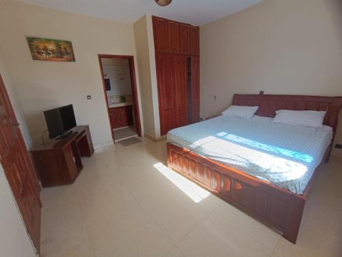 a bedroom with a bed and a flat screen tv at Blue House in Saly Portudal
