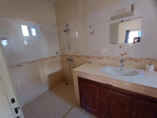 a bathroom with a sink and a mirror at Blue House in Saly Portudal