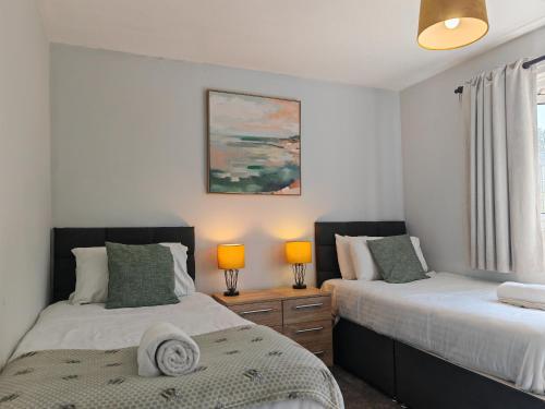 OtterbourneにあるPiping House 4bedroomのベッドルーム1室(ベッド2台、ランプ2つ、窓付)