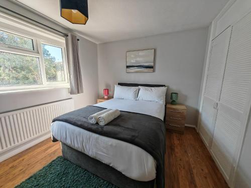 OtterbourneにあるPiping House 4bedroomの大きなベッドと2つの窓がある寝室