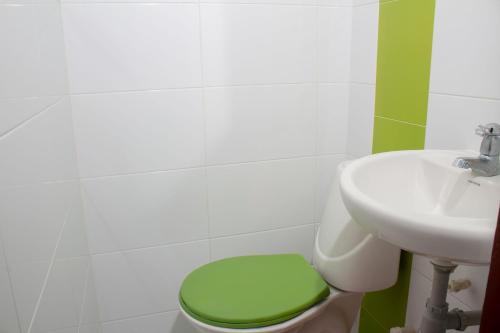a bathroom with a green toilet and a sink at Hotel Catedral inn B SAS in Barranquilla