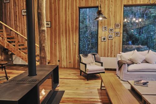 a living room with a couch and a fireplace at Lodge El Remanso, Patagonia Chile in Llanada Grande