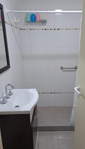 a white bathroom with a sink and a shower at Monoambiente luminoso impecable in Bahía Blanca