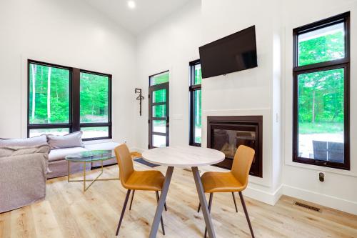 Una sala de estar con una mesa y sillas y un sofá. en Modern Bellaire Cabin Less Than 5 Mi to Lake and Slopes!, en Bellaire
