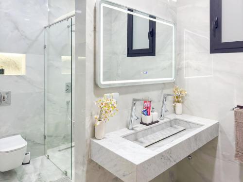 a white bathroom with a sink and a shower at Villa signature - Piscine prive - Spacieuse à Founty in Agadir