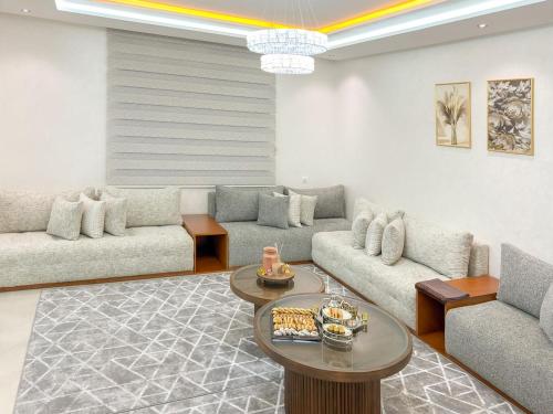 a living room with couches and a coffee table at Villa signature - Piscine prive - Spacieuse à Founty in Agadir