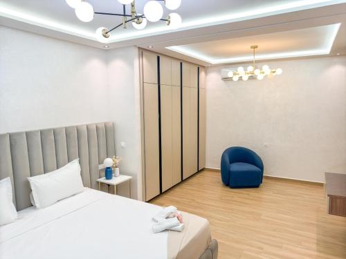 a bedroom with a bed and a blue chair at Villa signature - Piscine prive - Spacieuse à Founty in Agadir