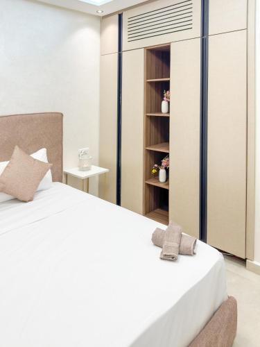 a bedroom with a white bed and a book shelf at Villa signature - Piscine prive - Spacieuse à Founty in Agadir