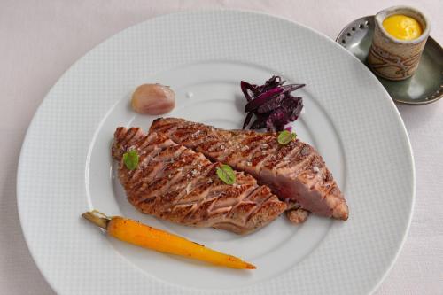 a plate of food with meat and a carrot at Il Miraggio in Val d'Orcia Relais & Spa in San Quirico dʼOrcia