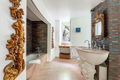 La salle de bains est pourvue d'un grand miroir et d'un lavabo. dans l'établissement Domaine de rêve, coeur de forêt de Fontainebleau, à Le Vaudoué