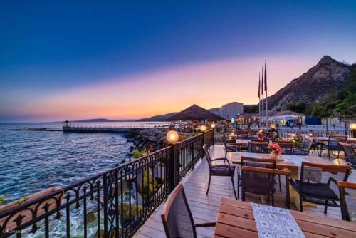a restaurant with tables and chairs next to the water at La Veranda Apartment, complex Carpe Diem, Free Parking & Swimignpool in Balchik