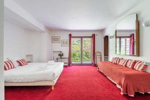 - une chambre avec 2 lits et un tapis rouge dans l'établissement Domaine de rêve, coeur de forêt de Fontainebleau, à Le Vaudoué