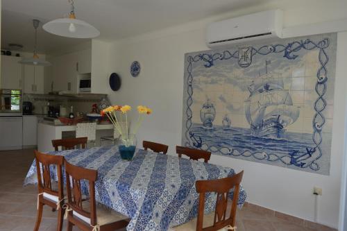 a dining room with a table and a painting on the wall at Villa Marquês in Vila Nova da Barquinha