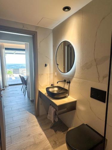 a bathroom with a sink and a mirror on the wall at Gialos Villas Paleochora in Palaiochóra