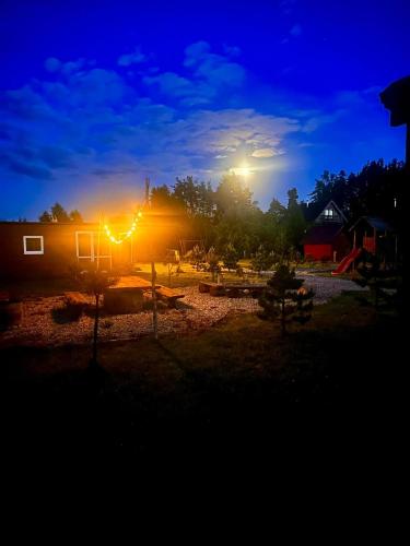 a house at night with the lights on at Domek uroczy i wilcza chatka,klimat górski na Kaszubach,balia,sauna,ognisko in Sikorzyno