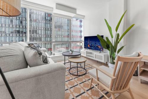 a living room with a couch and a tv at Stylist Downtown LA Gateway- Studio Apt in Los Angeles