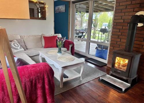 a living room with a fireplace and a couch at Domek uroczy i wilcza chatka,klimat górski na Kaszubach,balia,sauna,ognisko in Sikorzyno